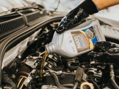 Person putting oil in an engine