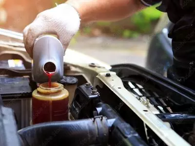 Person adding oil to an engine
