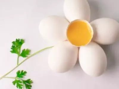 Cracked open duck egg with yolk exposed